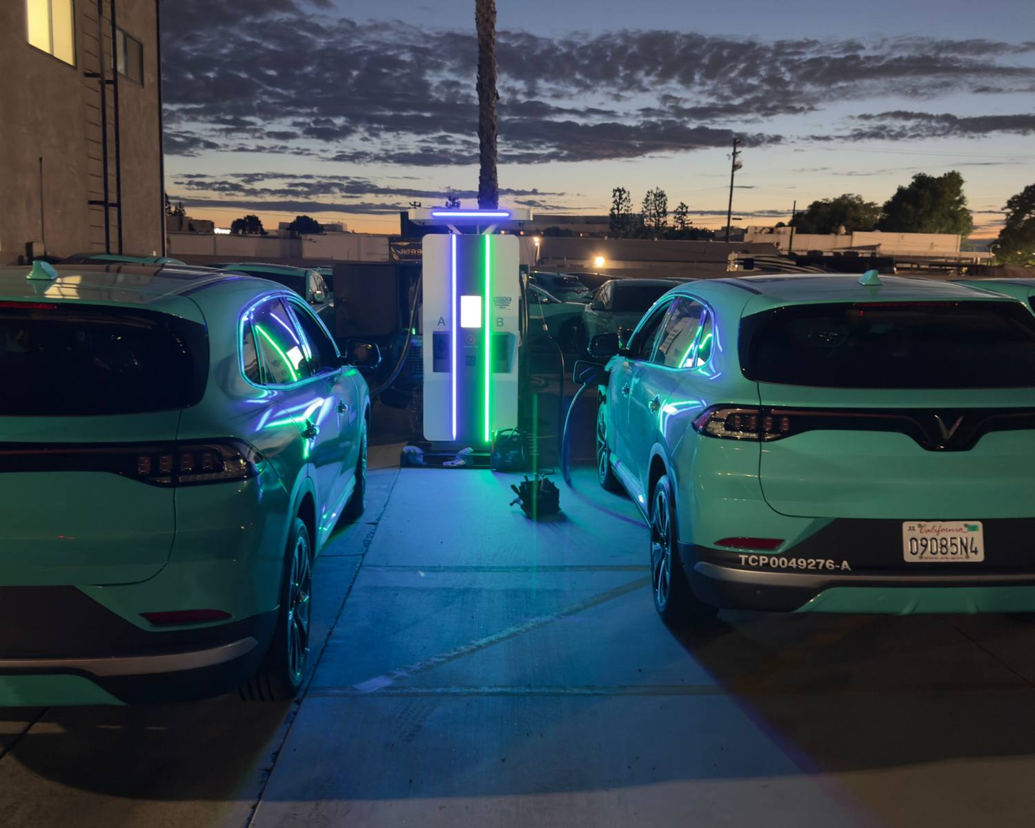 Rows of autonomous vehicles charging at 150 kW ports fed by a mobile power block inside a depot