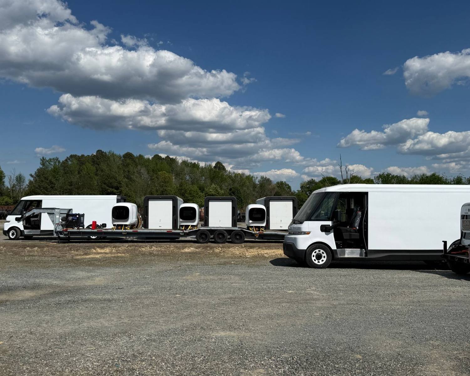 Delivery van depot at dusk with a mobile 700 kW power block feeding a row of DC dispensers