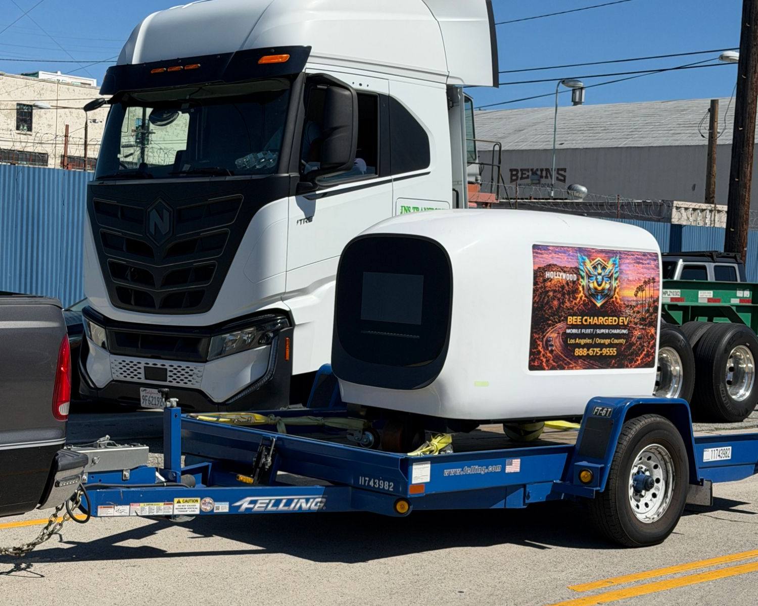 Mobile 1 MW power block and two 350 kW dispensers charging Class 8 electric trucks in a drayage yard at night